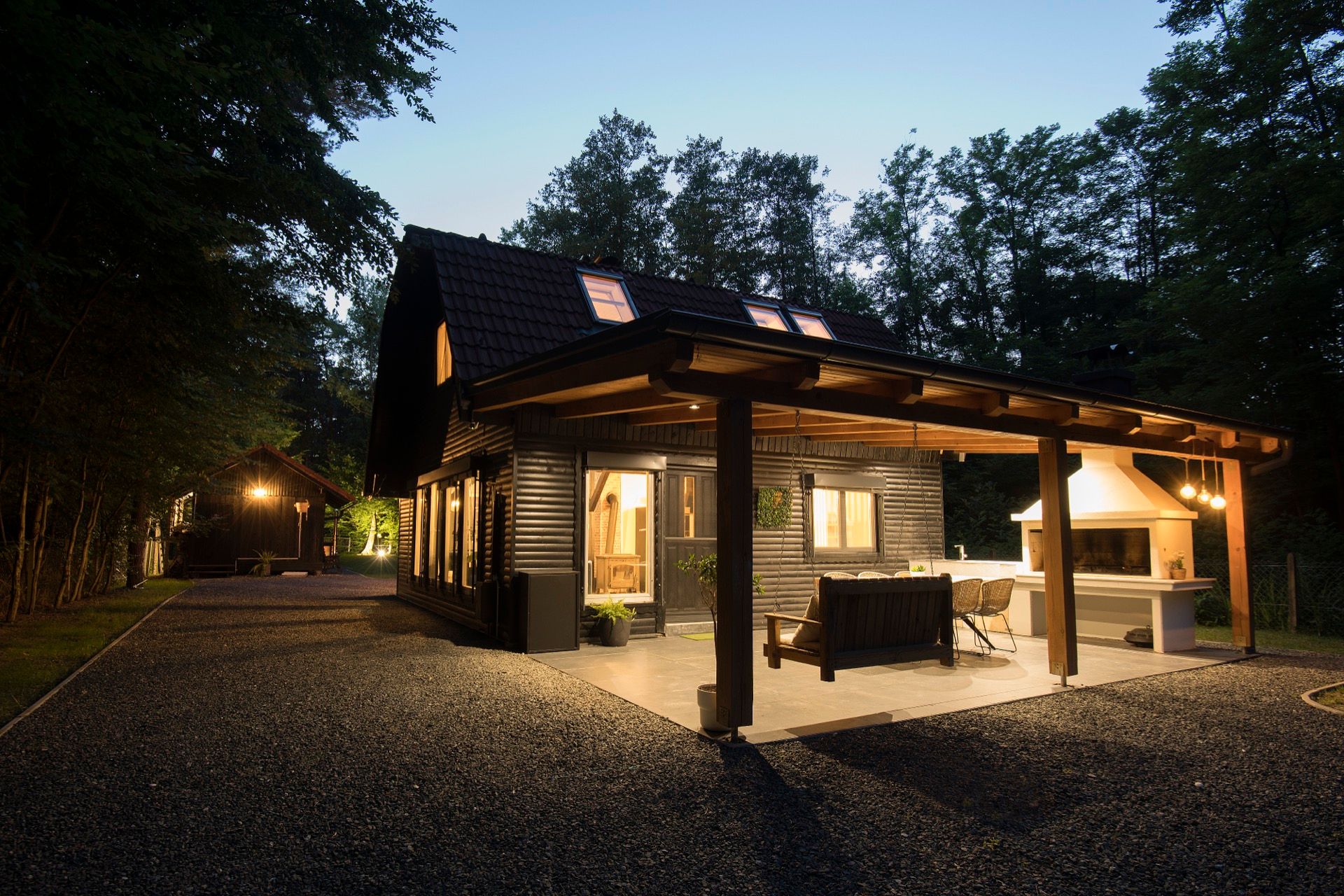 The Nest cabin lit up at dusk, surrounded by forest